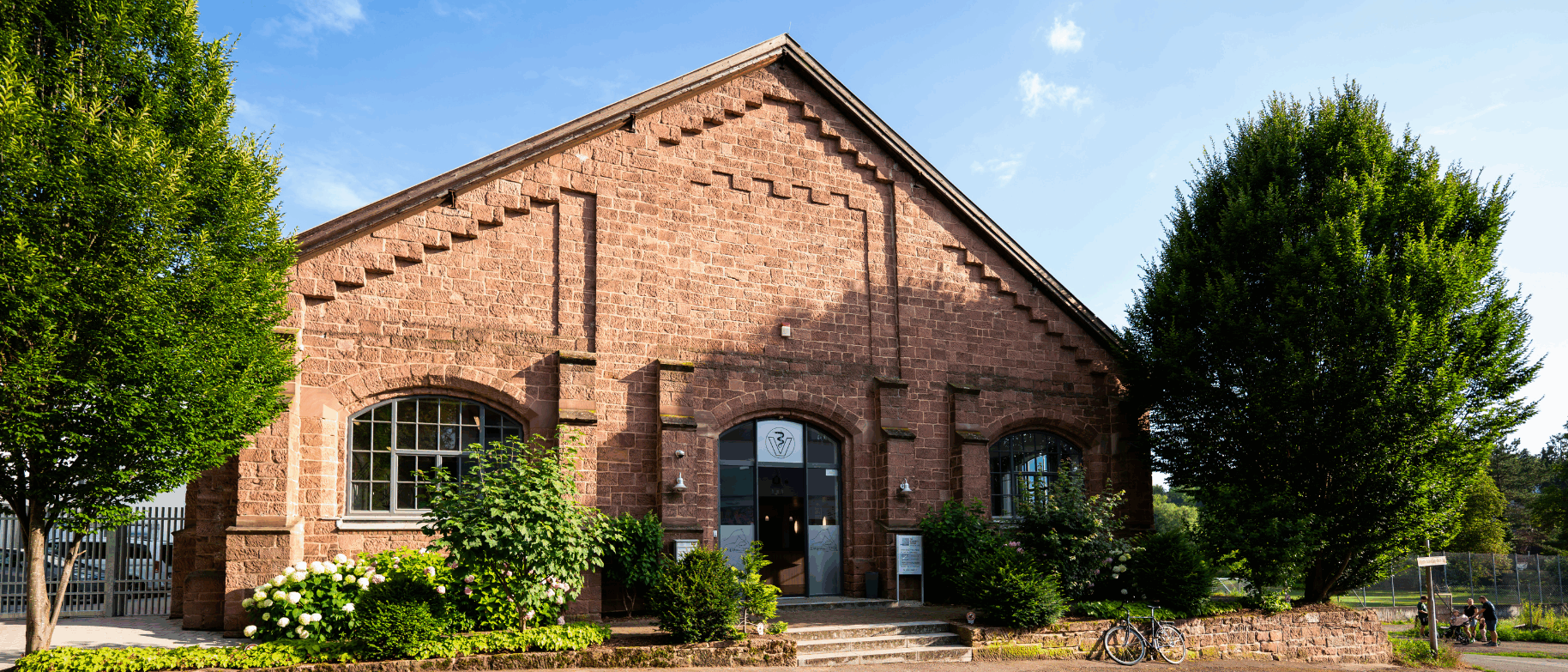 Unser Gebäude, ein wunderschönes Haus in rotem Backstein mit einem einladenden Eingangsbereich mit großer Glastür.